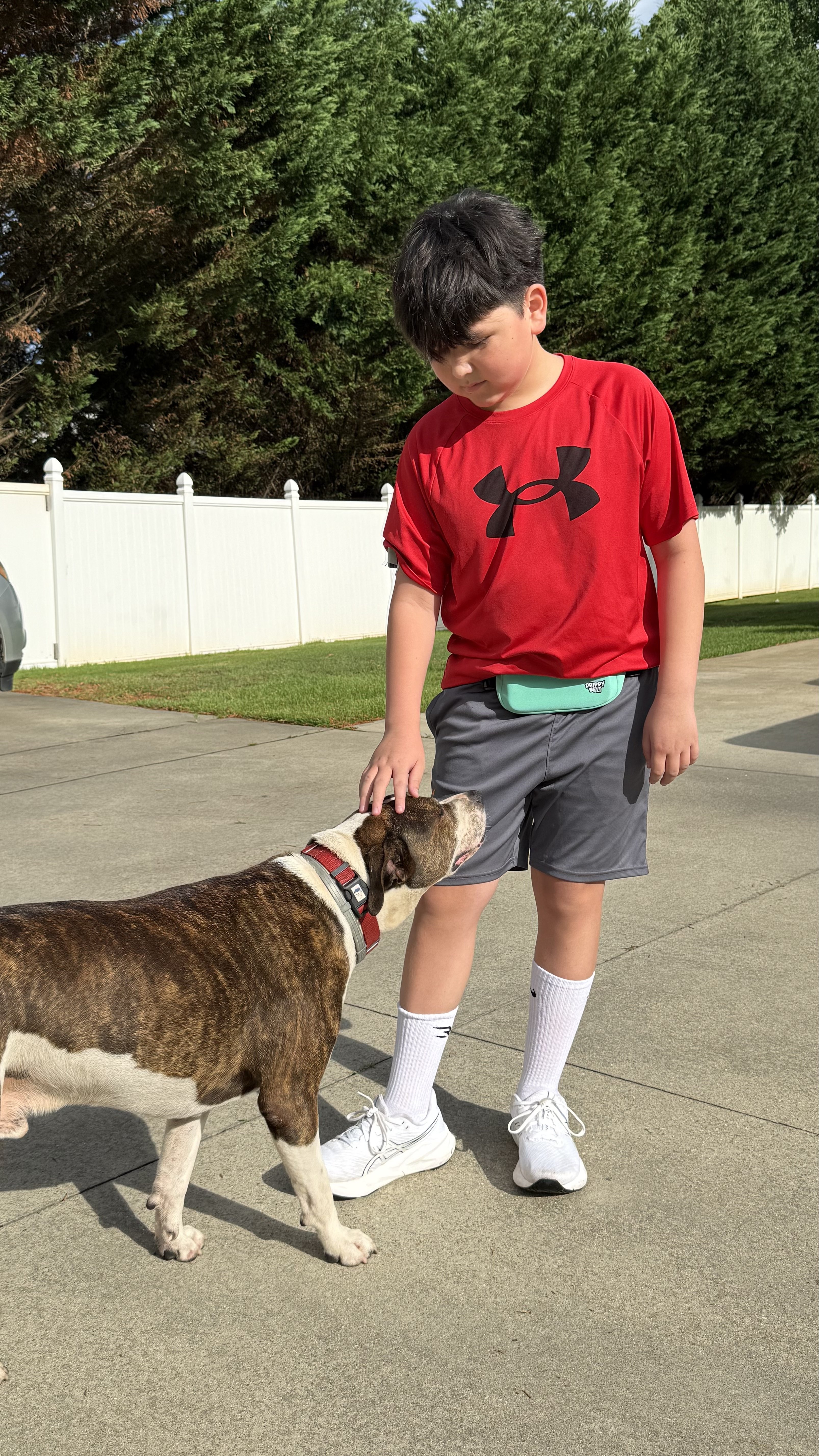 Finn, age 11, wearing his Drippy Belt teal while playing outside with his dog